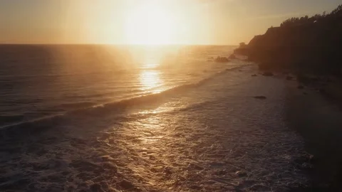 Drone shot of setting sun wavy ocean surface in twilight at El Matador Beach Stock Footage 137406680