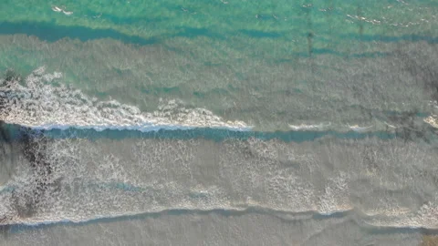 Drone shot showing waves rolling onto a beach Vídeo Stock 220360592