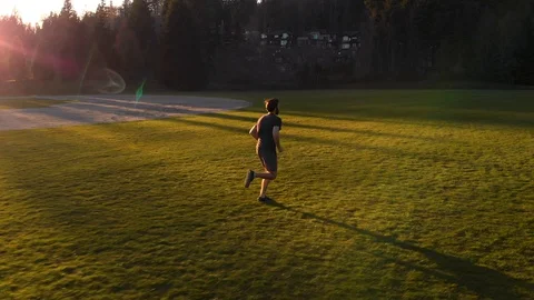 Drone shot in slow motion of a young healthy caucasian man jogging Stock Footage 129055258