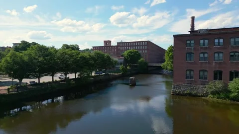 Drone shot slowly flying forward over a river toward an old brick mill in Stock Footage 331901208