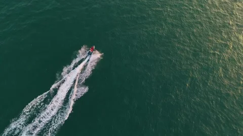 A drone shot of a small boat cutting through the water in the middle of the sea 動画素材 305214565