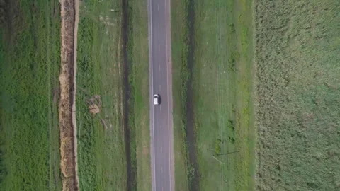 Drone shot of small car driving on road Stock Footage 264753209