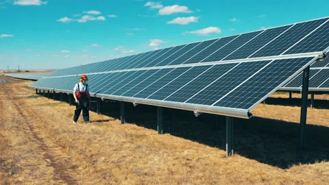 Drone shot of a solar panel technician inspecting solar panels in a solar park Video stock 142922155