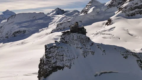 Drone shot of the Sphinx Observatory against the dramatic snowy landscape of Stock Footage 296587645