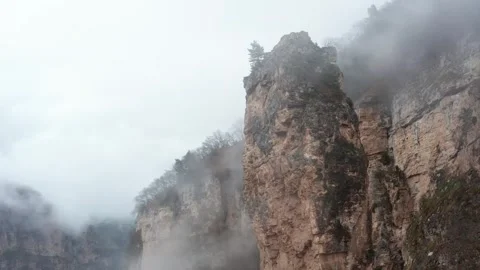 Drone Shot of Steep Rocks Covered with Dense Fog Stock Footage 280236298