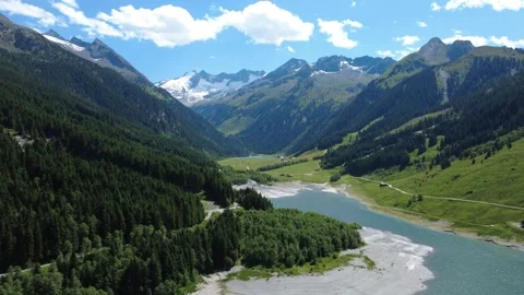 Drone Shot of a Stunning Alpine Valley with a Turquoise Lake and Snow-Cappe.. Stock Footage 333627407