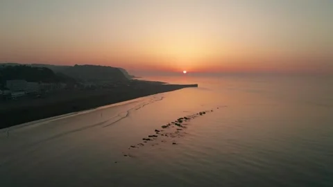 Drone shot of the sun rising over beach at low tide Stock Footage 342975919