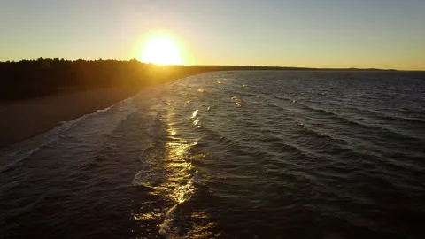 A drone shot of a sun set on a beach on the shore of Lake Superior in Michigan Stock Footage 136196501