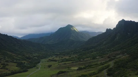 Drone shot of sunlit mountain under tropical clouds, Hawaii Stock Footage 126603633