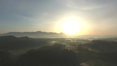 Drone shot of sunrise over Mount Kirishima with morning mist and city view. 4K. Stock Footage 328627900
