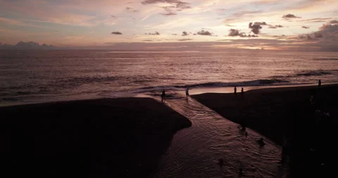 Drone shot of sunset in Bali. The river flows into the Pacific Ocean. People are Stock Footage 290005028
