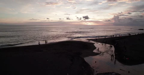 Drone shot of sunset in Bali. The river flows into the Pacific Ocean. People are Stock Footage 309413156