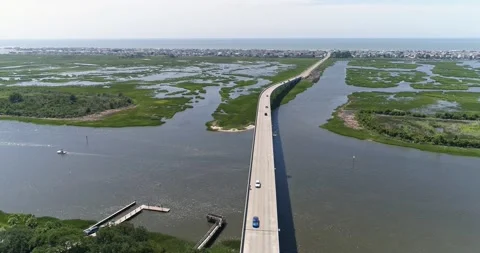 Drone shot of Sunset Beach Bridge on the Intercoastal Waterway with Sunset Beach Stock Footage 202343507
