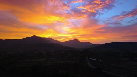 Drone shot of sunset over a mountain with bright colours 4K30 스톡 동영상 332893416