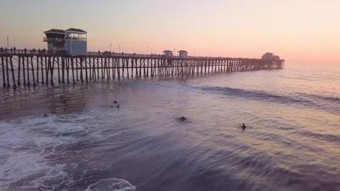 Drone  shot as surfer rides a wave in near the pier - San Diego, CA Stock-Footage 88258402