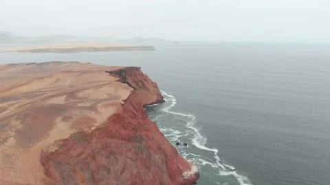 Drone shot of surreal red cliffs facing the ocean in Paracas, Perú Vídeos de archivo 119669091