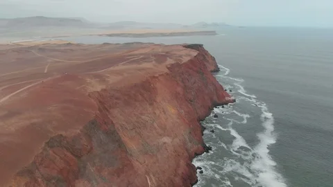 Drone shot of surreal red cliffs facing the ocean in Paracas, Perú Vídeos de archivo 119669113