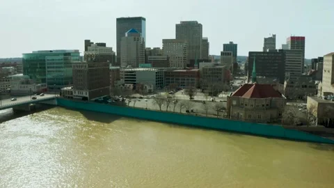 Drone shot of swollen river in spring revealing downtown Dayton Ohio skyline Stock Footage 150827465