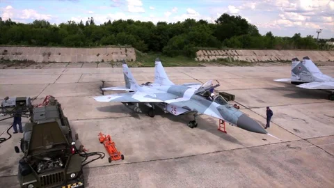 Drone shot of technical service inspecting military fighters MIG-29 after Stock Footage 73497708