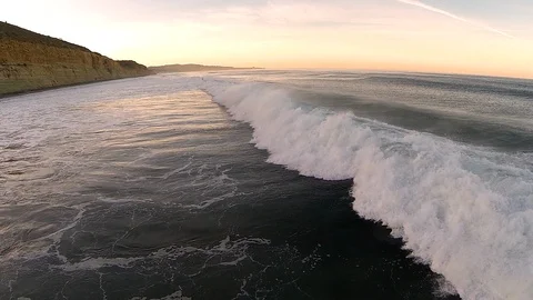 Drone shot of three ocean beach waves crashing in series close to shoreline. Stock Footage 126798228