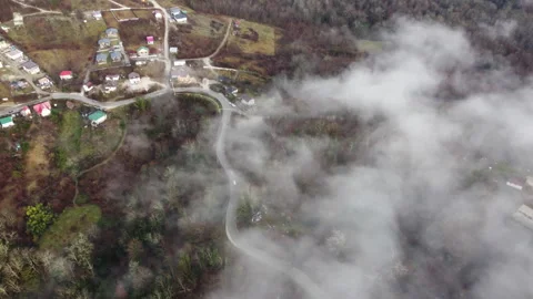 Drone shot through clouds of long mountain village on mountain Stock Footage 246627234
