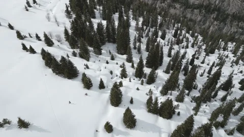 Drone shot tilting down into bird’s-eye view of snowy alpine mountainside Video stock 327965506