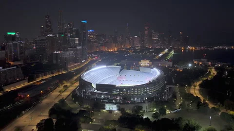 Drone shot tilting toward the illuminated, empty Soldier Field stadium, Chicago Stock Footage 321936203