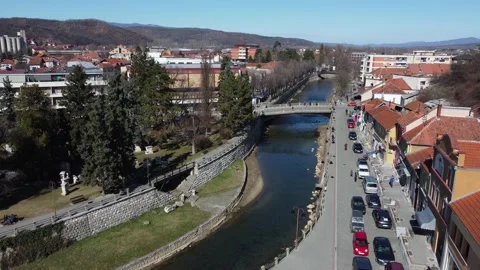Drone shot of a town square with a river, bridges and people walking Stock Footage 170876332