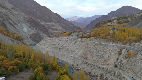 Drone shot tracing the curves of a river in autumn-clad Kargil Stock Footage 310661954