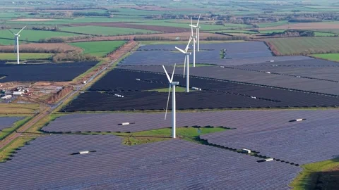 Drone shot tracking high voltage sustainable energy infrastructure driving the Stock Footage 336949479