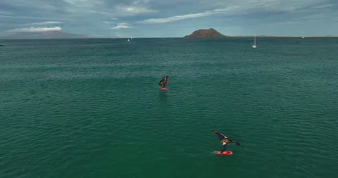 Drone shot tracking a kite surfer on a calm, blue sea Stock Footage 345424312