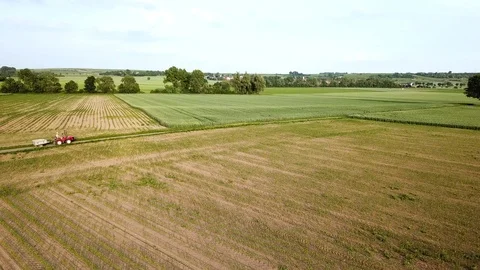 Drone shot tractor on landscape field farmer Stock Footage 100985201