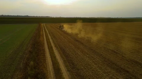 Drone shot of tractor pulling sowing machine on harvested field with straw Stock Footage 209619089