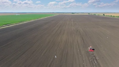 Drone shot of tractor seeding crops on agricultural field Stock Footage 148173015