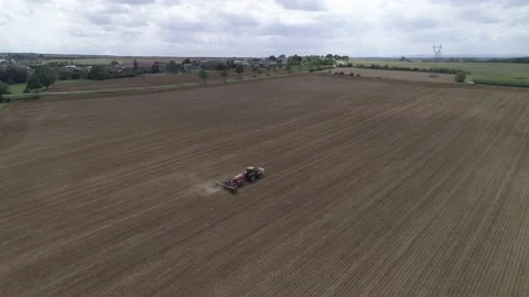 Drone shot of a tractor sowing in the field with dust behind Stock Footage 159807255