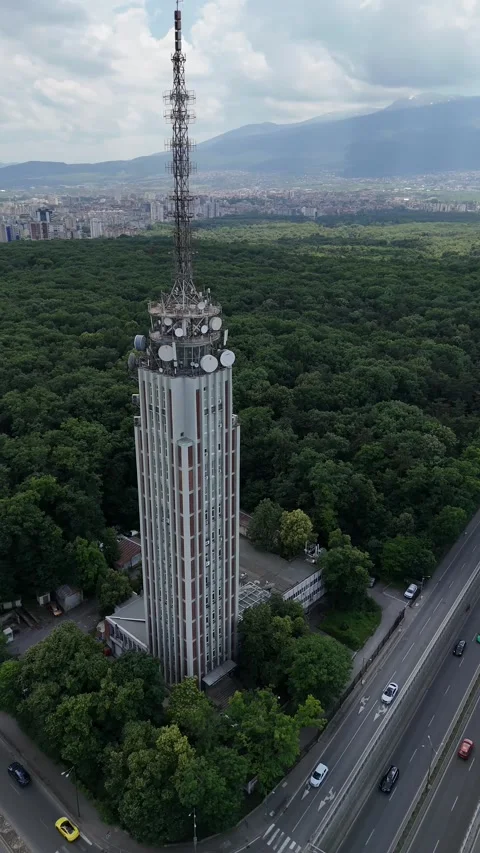 Drone shot of traffic circle and radio tower in the middle of a beautiful city Stock Footage 277374553