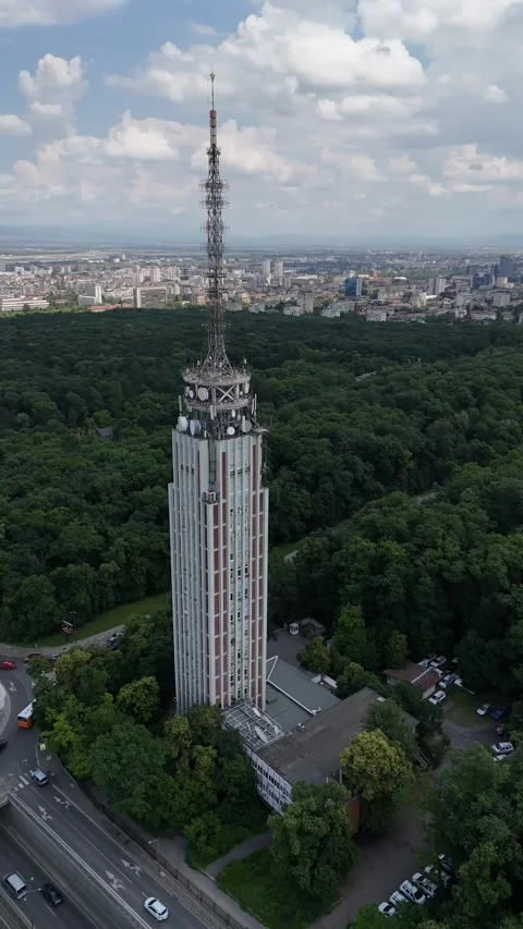 Drone shot of traffic circle and radio tower in the middle of a beautiful city Stock Footage 277375136