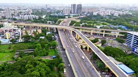 Drone shot traffic move steadily below metro rail structure Stock Footage 313278688