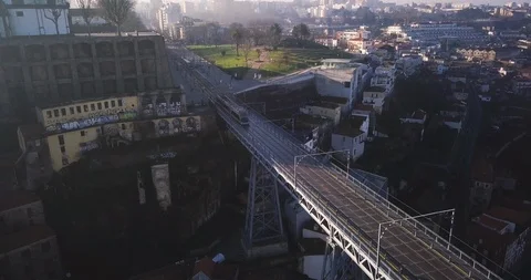 Drone shot of a train moving on railroad bridge above the river in Porto Stock Footage 114854463
