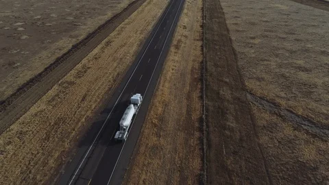 Drone shot of trucks passing on desolate highway. Stock Footage 118575401