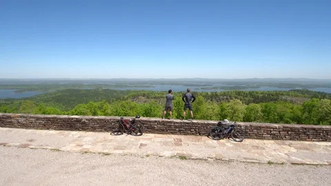Drone Shot of Two Bikers Overlooking Beautiful Lake Stock Footage 95944919