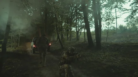 Drone shot of two equipped men in military uniform holding weapons moving in Stock Footage 235669705