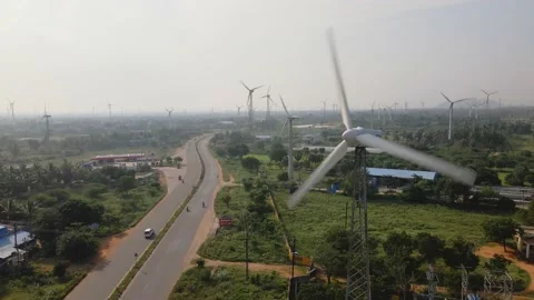 Drone shot of a two-lane busy roadway dividing huge farm of wind turbines Stockbeeldmateriaal 154367623