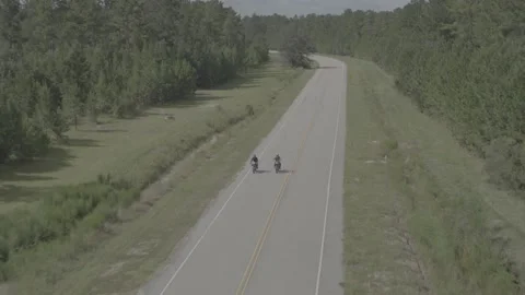 Drone shot of two motorcycles ride down deserted country road Stock Footage 220579257