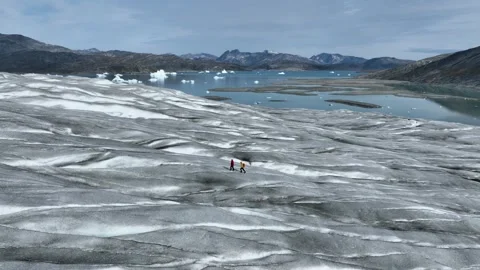 Drone shot of two people walking on Greenland inland ice sheet Stock-Footage 332380208