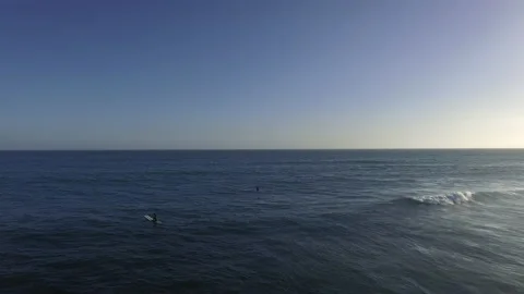 Drone shot of two surfers sitting in the ocean waiting for a wave Vídeo Stock 133040513