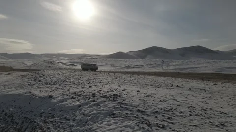 Drone shot of van driving across snowy landscape Video stock 244324946