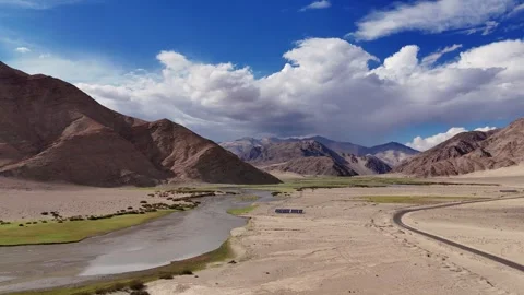 Drone shot of vast mountains cradle lush pastures and glacial water Stock Footage 310899250