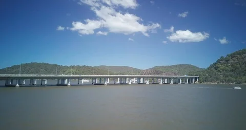 Drone shot of vehicles moving on flyover over calm sea Stock Footage 122445264