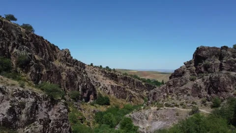 Drone shot of volcanic rock gorge and wild valley during dry summer, Kazakhstan Видео 337644964